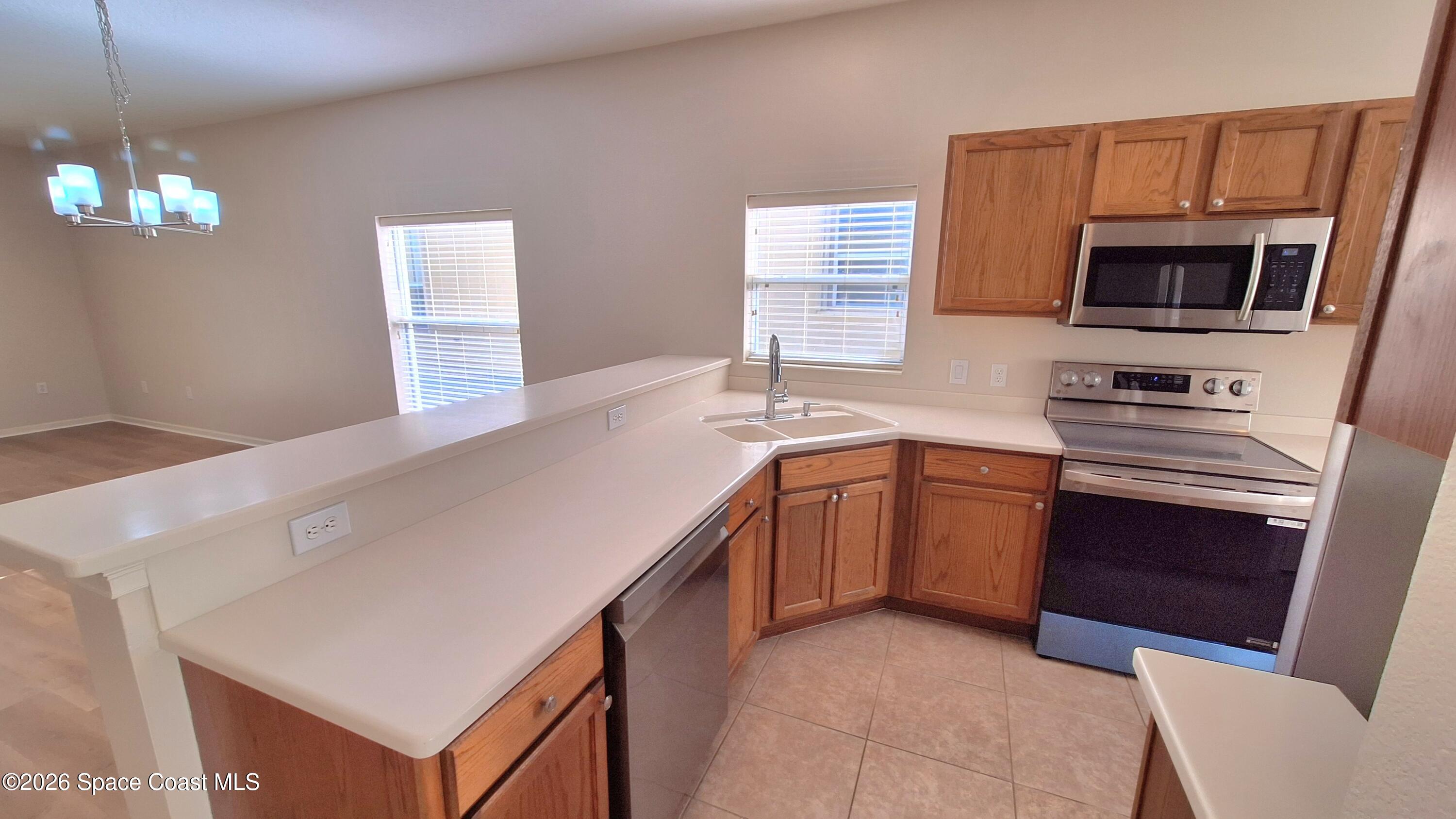 6921 Abbeyville Road Melbourne, FL 32940 - Photo 19 of 24 a kitchen with a sink a stove and microwave