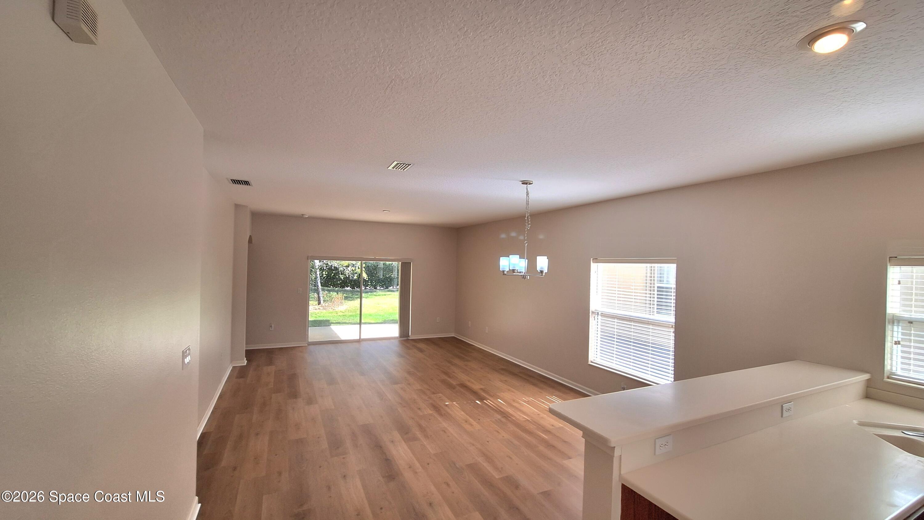 6921 Abbeyville Road Melbourne, FL 32940 - Photo 8 of 24 a view of empty room with window and wooden floor