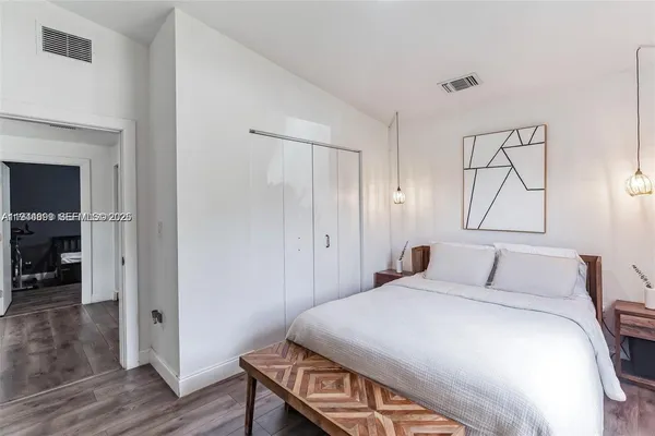 a bedroom with a bed and wooden floor