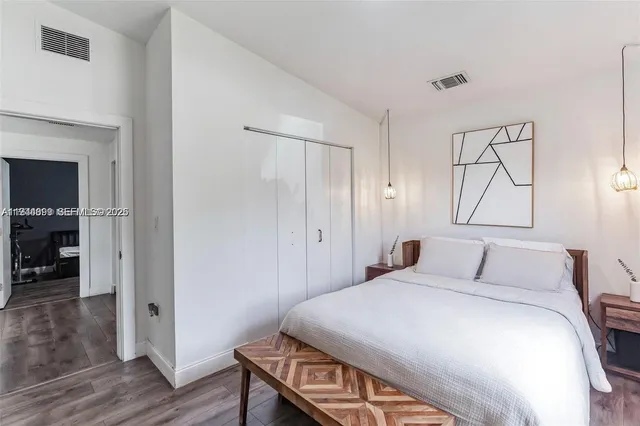 a bedroom with a bed and wooden floor