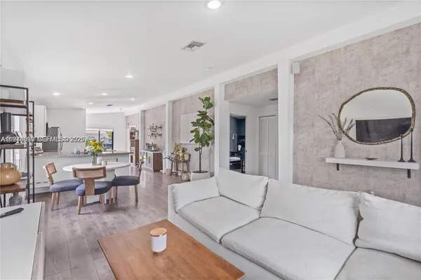 a living room with furniture and view of kitchen