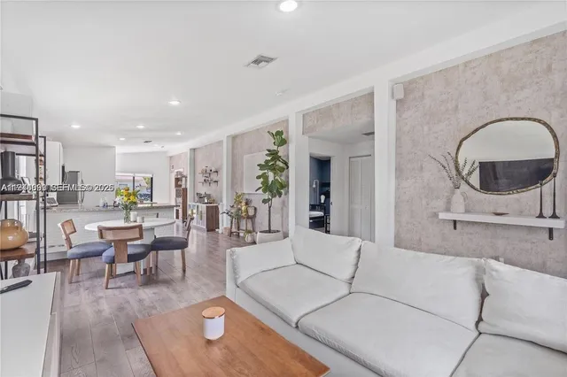 a living room with furniture and view of kitchen