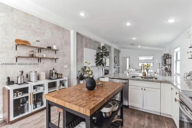 a kitchen with cabinets appliances and furniture