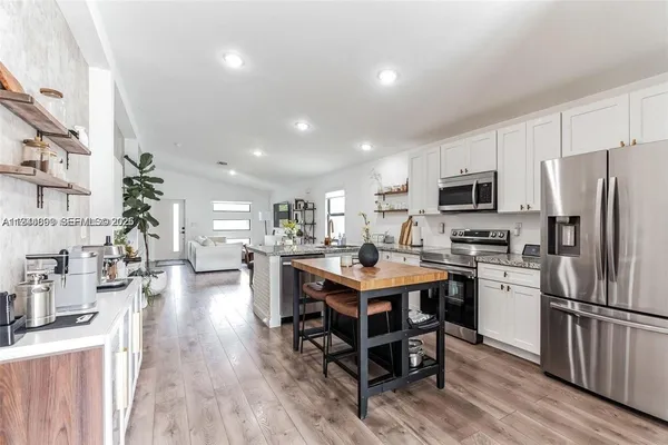 a kitchen with a sink a counter top space stainless steel appliances and cabinets