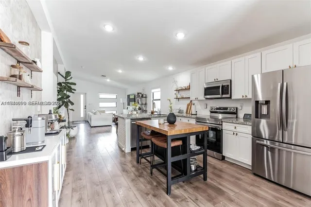 a kitchen with a sink a counter top space stainless steel appliances and cabinets
