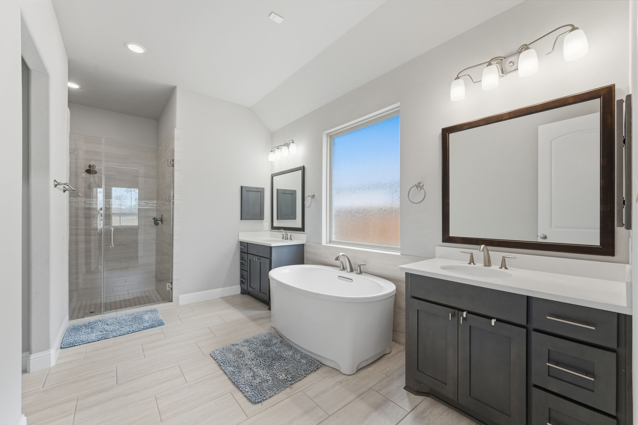 28117 Woodland Bend Way Spring, TX 77386 - Photo 26 of 48 Primary bath in complete with double vanities, a soaking tub, and walk-in shower.