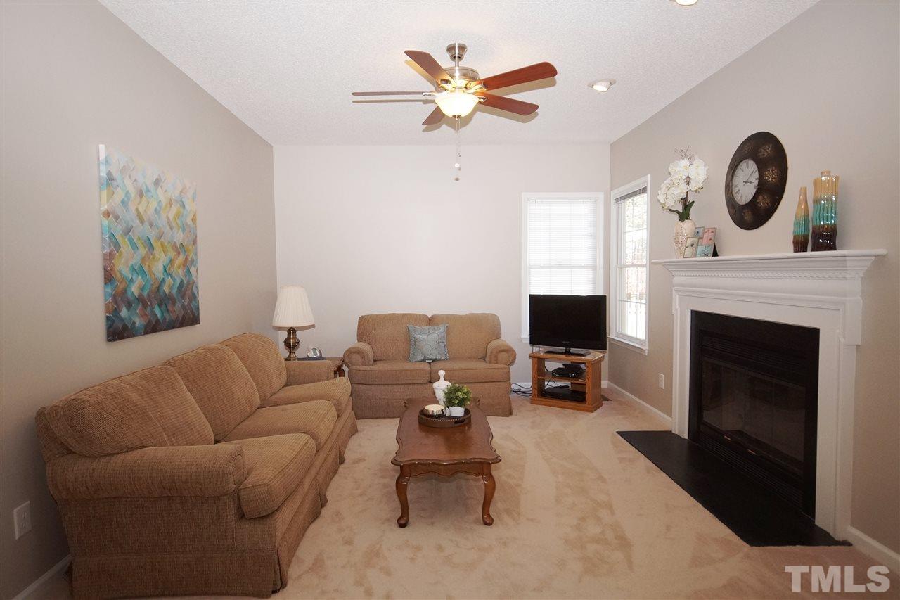 5249 Fairmead Circle Raleigh, NC 27613 - Photo 12 of 25 a living room with furniture a clock and a fireplace