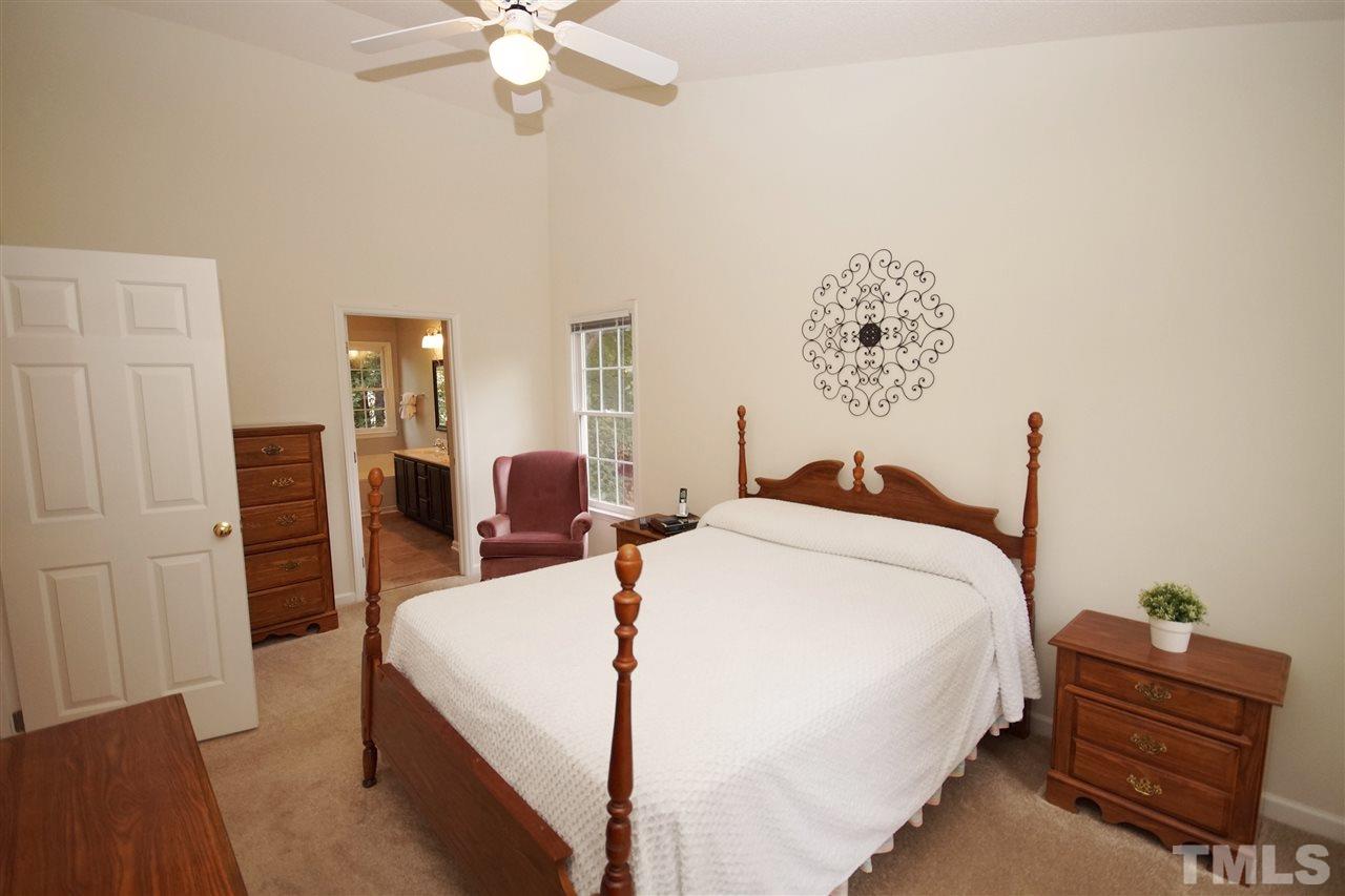5249 Fairmead Circle Raleigh, NC 27613 - Photo 15 of 25 a bed room with a bed and a chandelier