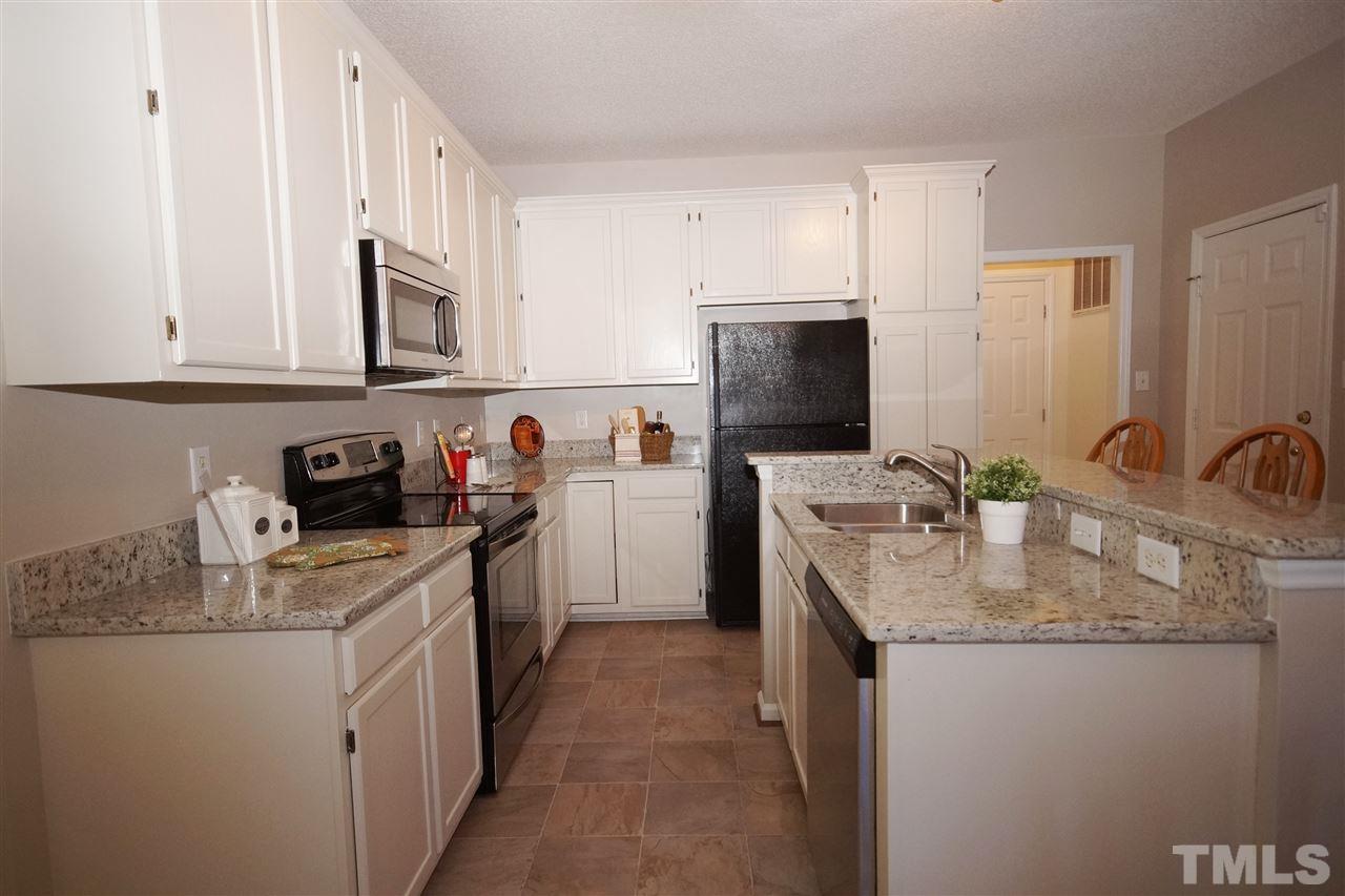 5249 Fairmead Circle Raleigh, NC 27613 - Photo 6 of 25 a kitchen with stainless steel appliances granite countertop a sink stove refrigerator and cabinets