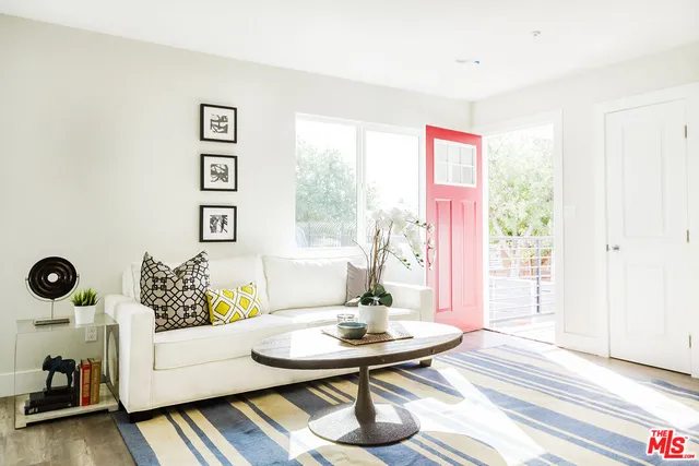 a kitchen with stainless steel appliances a dining table chairs and a refrigerator