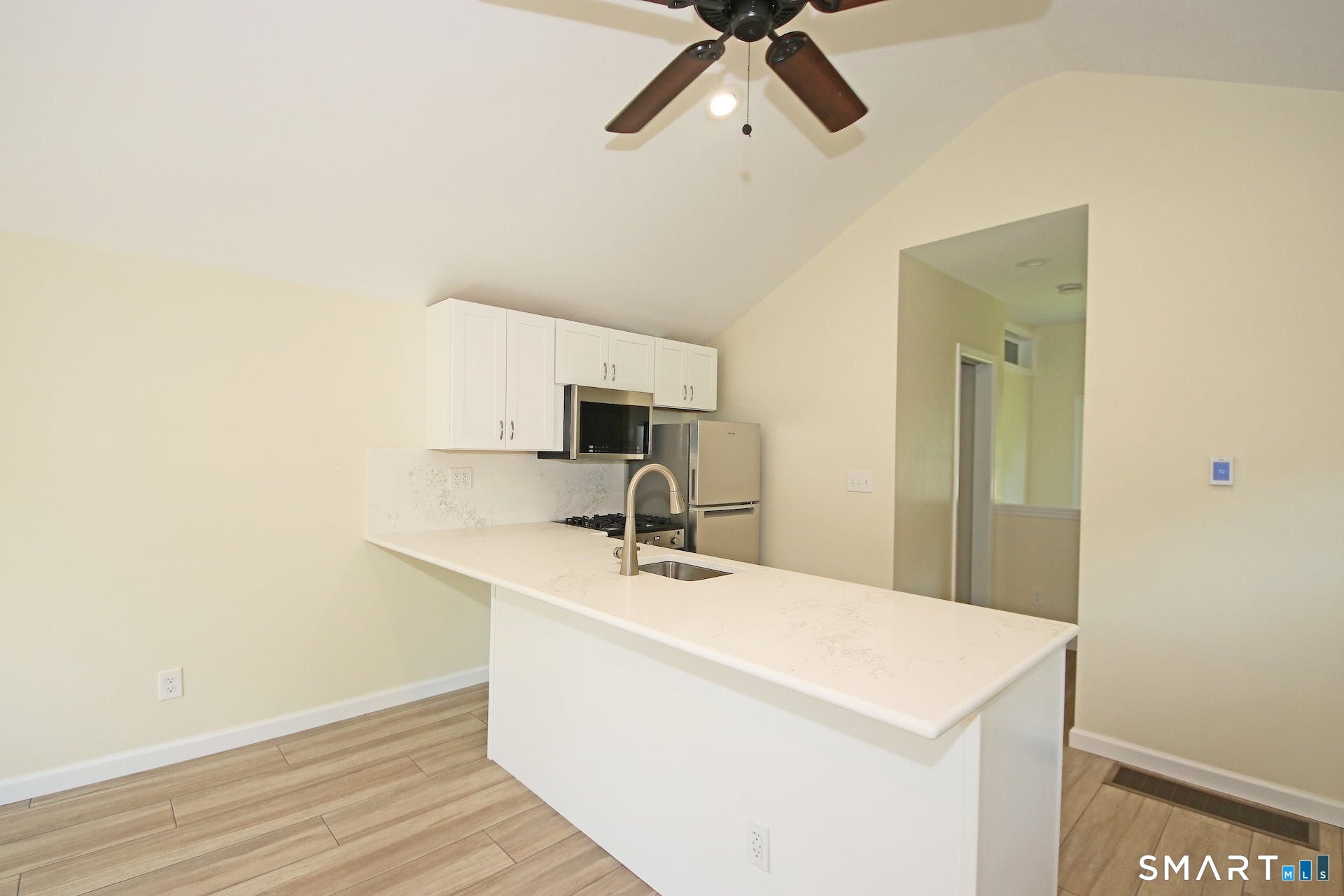 3509 Redding Road Fairfield, CT 06824 - Photo 18 of 27 a room with a sink a mirror and furniture