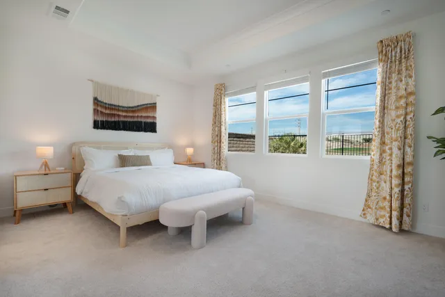 a spacious bedroom with a bed and a large window