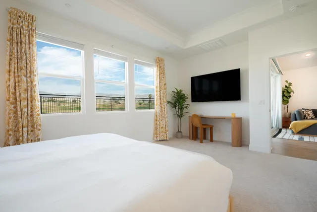 a bedroom with a large bed and a flat screen tv