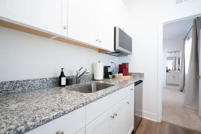 a kitchen with stainless steel appliances granite countertop a sink and a refrigerator