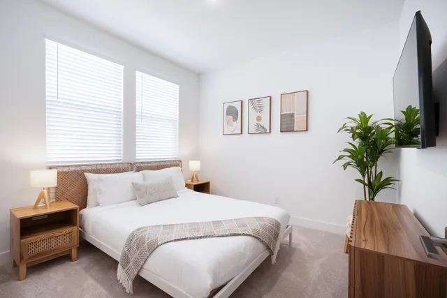 a bedroom with a bed and a potted plant