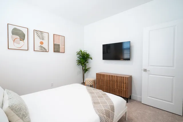 a bedroom with a bed and a flat screen tv