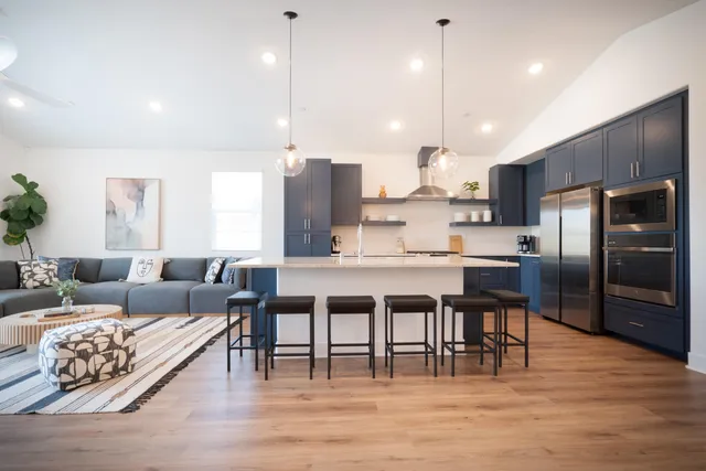 a large kitchen with a table chairs refrigerator and microwave