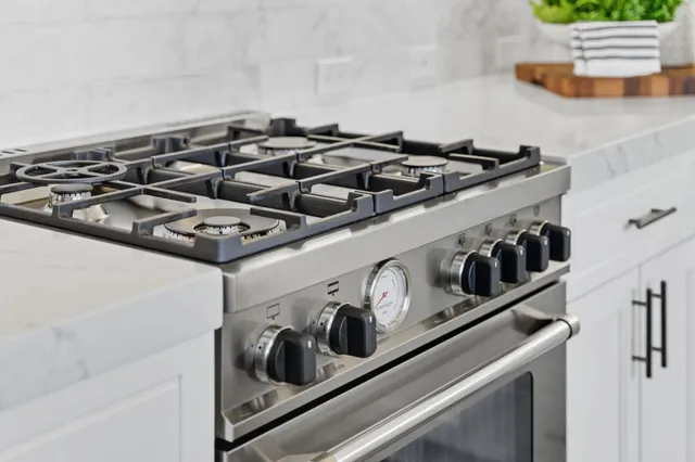 a kitchen with stainless steel appliances white cabinets and a stove