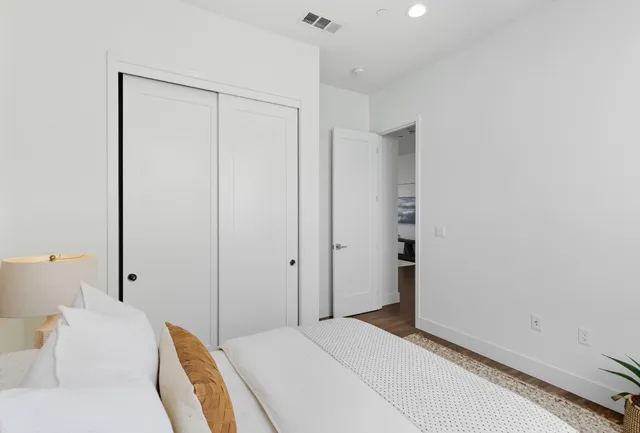 a bedroom with a bed and a potted plant