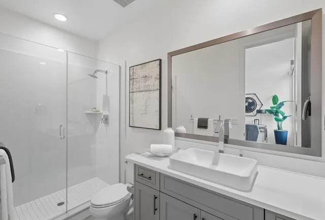 a bathroom with a sink a toilet and shower