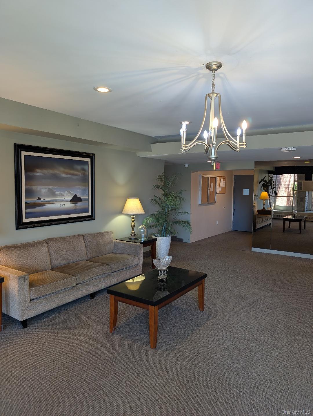 30 South Cole Avenue, Unit 6L Spring Valley, NY 10977 - Photo 11 of 13 a living room with furniture and a chandelier