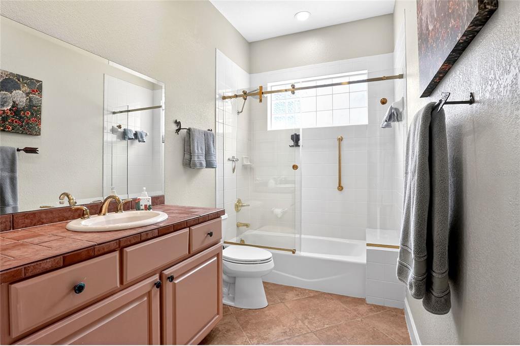 2968 Plantation Road Winter Haven, FL 33884 - Photo 44 of 81 a bathroom with a granite countertop sink toilet and shower