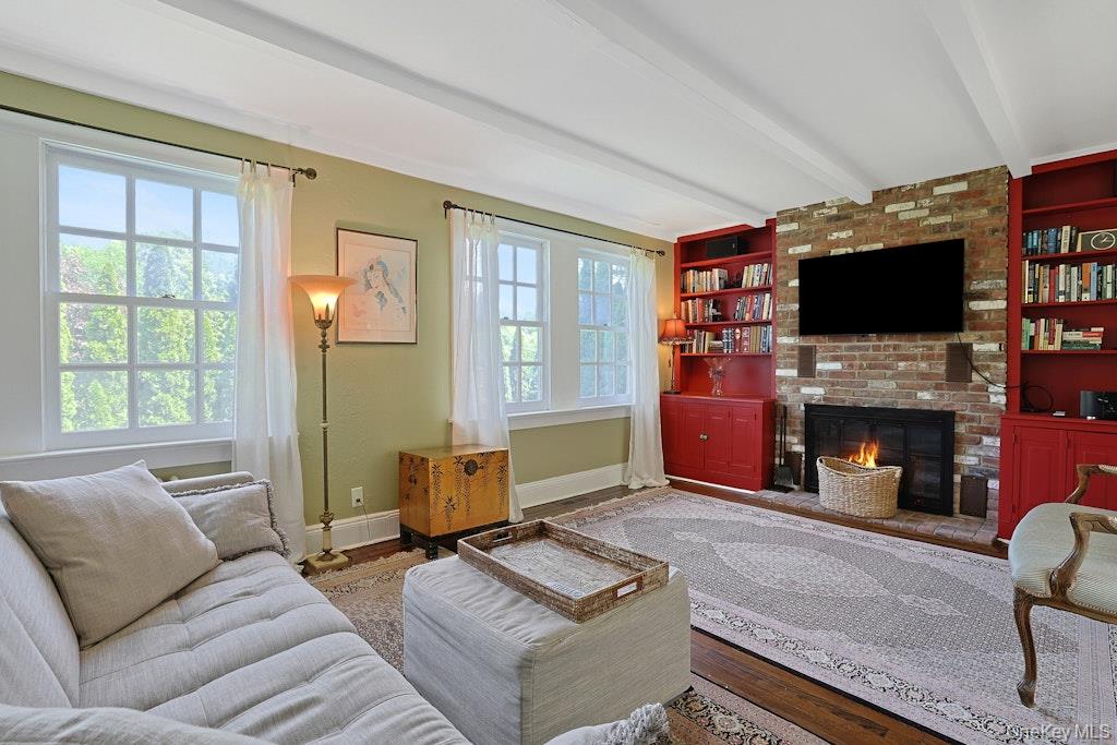 97 Underhill Road Scarsdale, NY 10583 - Photo 14 of 39 a living room with furniture a fireplace and a flat screen tv