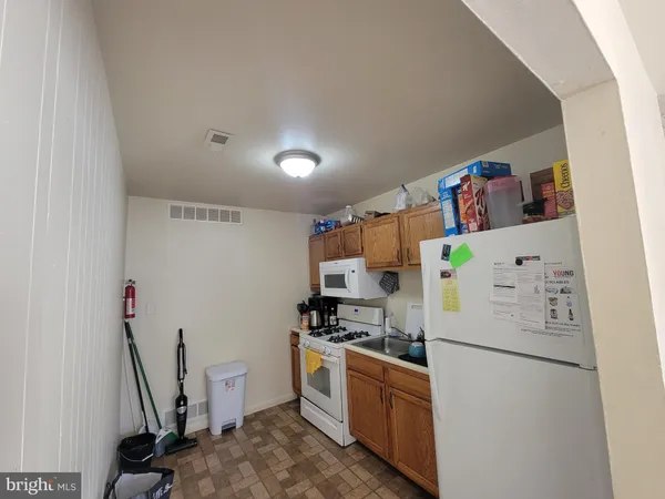 a kitchen with a refrigerator a stove top oven a sink and a counter top space