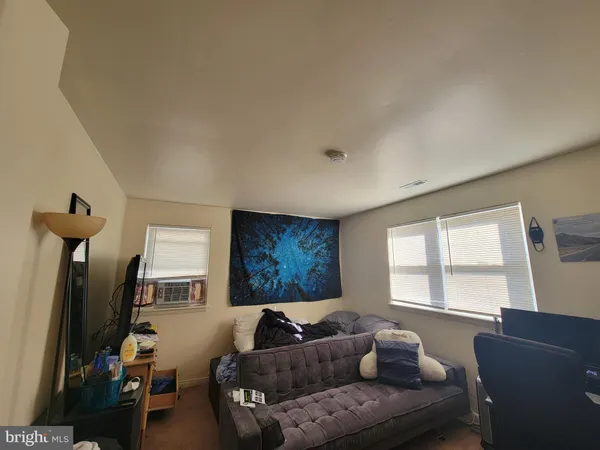 a living room with furniture a window and a flat screen tv