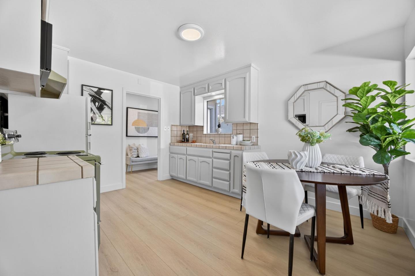 1236 Whitton Avenue San Jose, CA 95116 - Photo 10 of 30 a living room with furniture a potted plant and a kitchen view