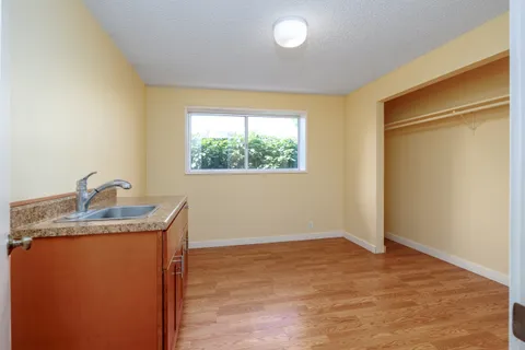 a view of a big room with windows and chandelier fan