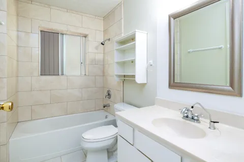 an empty room with a window and a ceiling fan