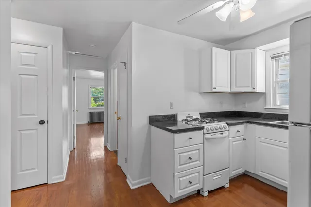 a kitchen with white cabinets and white appliances
