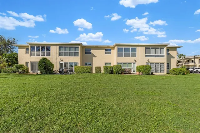 a front view of a house with a yard and outdoor seating