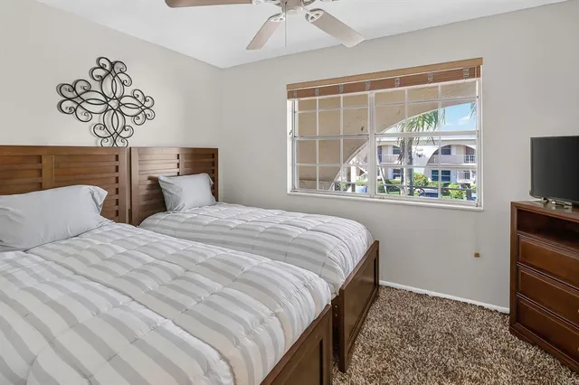 a bedroom with a bed and a flat tv screen on dresser