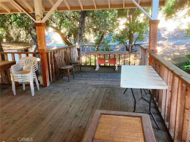 a view of a patio with table and chairs with wooden floor and fence