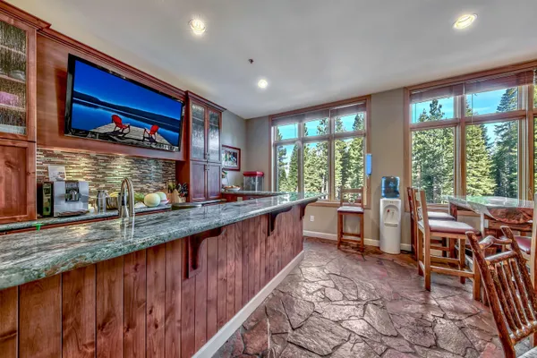 a large kitchen with kitchen island granite countertop a large counter top space and stainless steel appliances