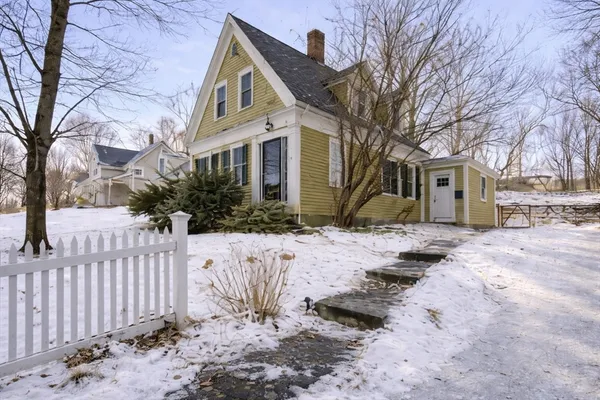 a front view of a house with a yard covered in snow