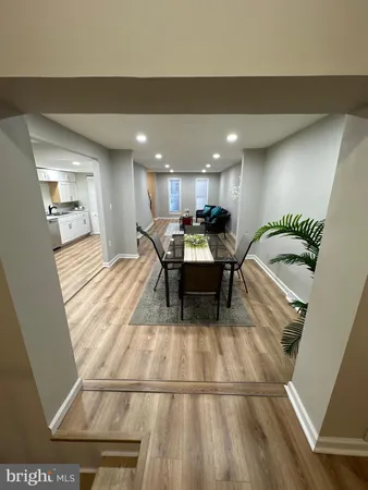 a view of an empty room with wooden floor and windows