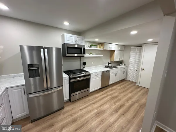 a kitchen with granite countertop a refrigerator stove and microwave