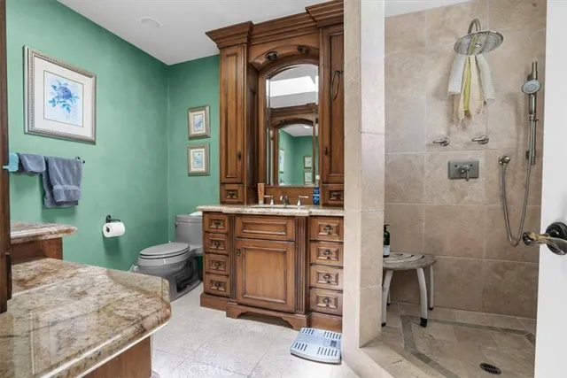 a bathroom with a granite countertop sink toilet and shower