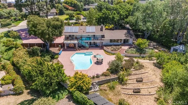 a aerial view of a house with swimming pool and large trees