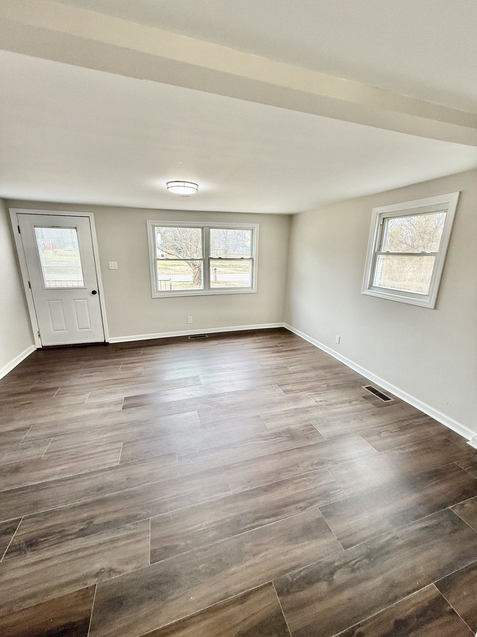 141 Main Street Gracey, KY 42232 - Photo 3 of 16 a view of an empty room with wooden floor and a window