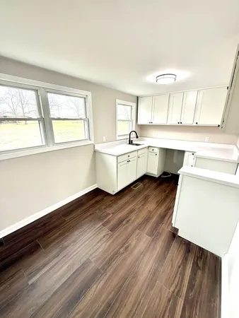a kitchen with wooden floors and white appliances