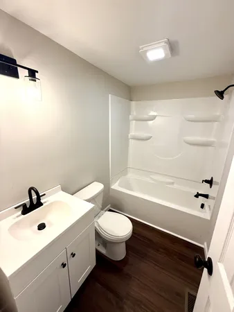 a bathroom with a sink a toilet a tub and shower