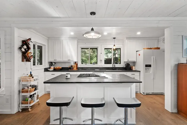 a kitchen with stainless steel appliances granite countertop a sink and a refrigerator