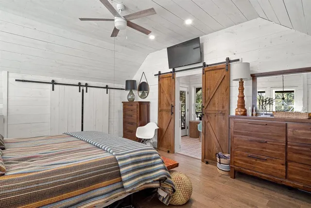 a bedroom with a bed and a flat tv screen