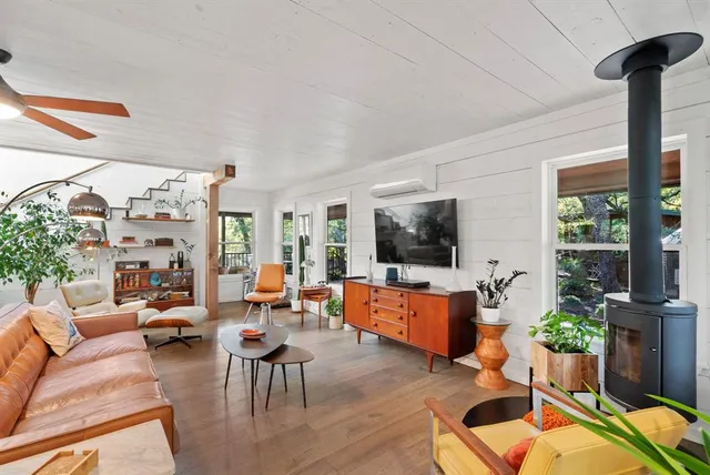 a living room with furniture large window and flat screen tv