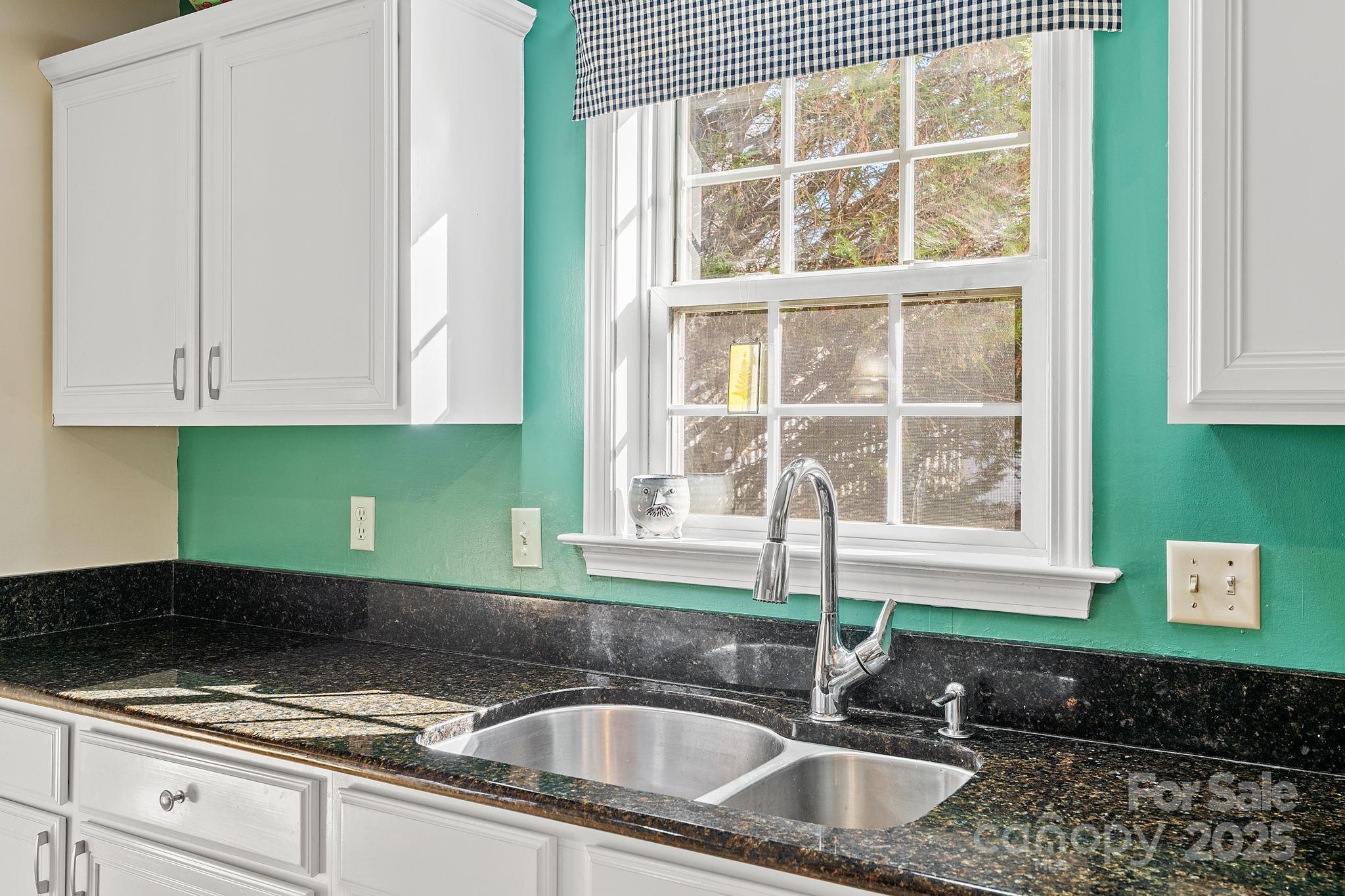 28 Sand Pebble Court Fletcher, NC 28732 - Photo 10 of 35 a kitchen with granite countertop a sink a window and cabinets