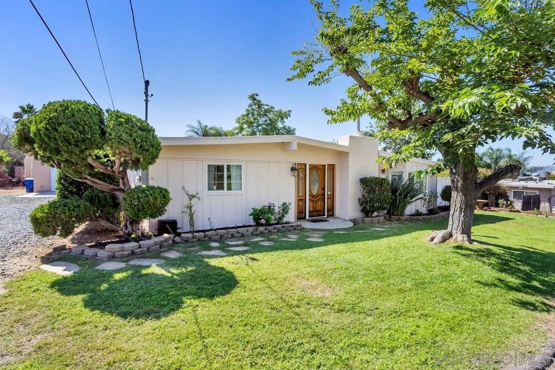 a view of a house with backyard and sitting area